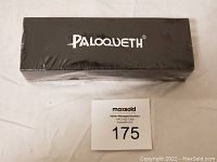 Sealed black rectangular box with Paloqueth branding on top, minor packaging damage visible.