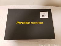 Black box with 'Portable monitor' printed in bold yellow lettering on lid.