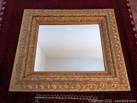 Full view of the gilt wood framed antique mirror showing rectangular shape and carved decorative frame.
