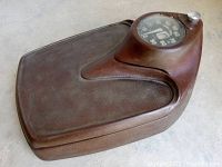 Angled top view showing textured dark brown cast iron platform and weight dial.