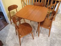 Assembled expanding teak dining table with four chairs