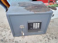 Closed Sentry Safe showing top paint flaking and front digital keypad plus key lock.