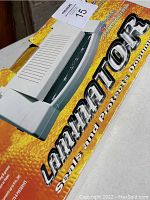 Photo of the laminator box showing the device and branding.