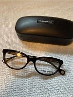 Photo of eyeglass frames and hard case on textured white surface