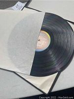 Photo of a vinyl LP partially pulled out of a plain white inner sleeve showing the Capitol Records label on the record center.