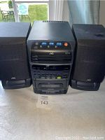 Full front view of the JVC compact stereo system with both speakers placed on either side of the main unit.