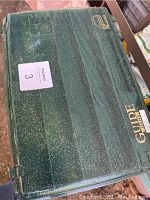 Green Plano Guide 14 inch fishing tackle box closed view showing logo and exterior.