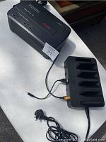 APC Back-UPS ES 350 battery backup with power outlets and associated multi-device charging dock on white surface