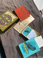 Photo showing multiple vintage card game boxes including two Rook card game boxes with blue covers featuring a black bird, an additional red box labeled Rook, and a Venture card game box with colorful cityscape artwork.