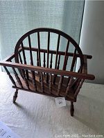 Front and side view of vintage wooden magazine rack with spindles and handle