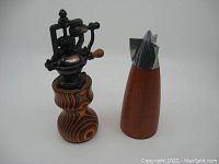 Two pepper mills shown together on white background, highlighting size and design differences.