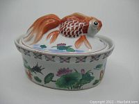 Front view of the antique Chinese porcelain tureen with a koi fish lid showing famille rose hand painted decoration