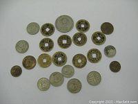 Top view of 23 coins arranged in rows on white background, showing Russian and Chinese coins.