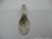 Front view of the sterling silver indigenous feast spoon pendant showing carved patterns inside the bowl and handle.