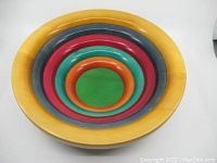 Top-down view showing concentric colorful rings of the wood bowl, highlighting colors yellow, dark blue, red, green, and orange.