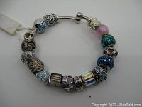 Full view of the sterling silver Persona charm bracelet with 17 assorted beads in multiple colors and designs including blue and pink accents.