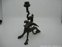 Front angled view showing detailed griffin/dragon form and candlestick holder.