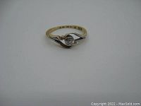 Oblique top-front view showing round diamond in platinum setting and two-tone gold band