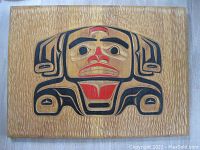 Front view of the carved Indigenous wood wall hanging showing the painted design with bold black and red lines and shapes on natural wood.