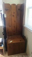 Front view of wooden Amish prayer bench showing tall back with two small shelves and seat panel.