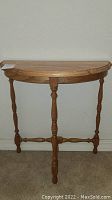 Front view of wooden demi lune hallway table showing semi-circular top and turned legs