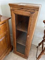 Full view of the oak wood display cabinet with glass door showing the front and side profile.