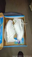 Pair of white women's Dr Scholl's Fitness Walker shoes in box showing side profile and sole