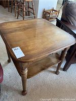 Top view of the square wooden end table showing smooth surface and turned legs