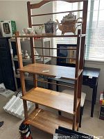 Front view of the four-shelf wooden bakers rack showing its overall structure and finish.