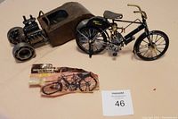 Photo showing the Harley-Davidson metal motorcycle replica and the hot rod metal car model side by side with a booklet describing the Harley model.