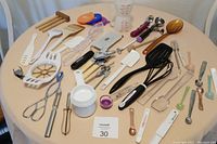 Top-down view of all kitchen tools arranged on a table including an apple slicer, measuring cups, and various utensils