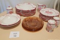 Full set showing pink and white ceramic plates, brown plastic plates, and ceramic shakers, sugar cup, creamer