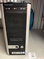 Front view of Cooler Master tower computer showing black mesh front panel with built-in 3.5 inch floppy drive, power button, control knob, Intel Pentium D and Intel sticker, and LG DVD drive.