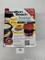 Box of Hamilton Beach Breakfast Sandwich Maker showing front panel with product image and key features.