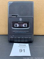 Front view of GE personal portable cassette recorder/player showing cassette tape inside, buttons, speaker grille, and GE logo
