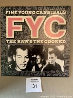 Front cover of Fine Young Cannibals vinyl album titled "The Raw & The Cooked" showing band members and album title.