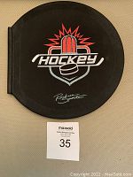 Front cover of the hockey puck shaped hockey book showing hockey logo graphic and Ruckus Sports branding
