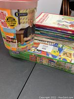 Overall lot showing Tutti Frutti modeling compound tub, scrapbook kit, and educational booklets stacked