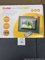 Box front showing Kodak EasyShare SV811 digital picture frame specifications: 8-inch screen, 128MB memory, 800x480 resolution, remote control included.