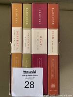 Four Larousse Gastronomique recipe books in slipcase, colorful spine titles.
