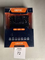 Front view of the mini drone integrated into the remote control inside original packaging, new in open box condition.
