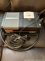 Top view of the Motomaster 12V air compressor showing pressure gauge and attached power cord.