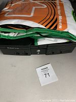 Original Xbox console partially covered by gaming mat, showing front ports and power buttons