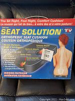 Front side of the box showing product name, posture illustration, and benefits including relief of backaches, fatigue, discomfort, soreness, numbness.
