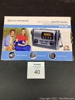 Photo of product box front showing Electrohome hand crank AM/FM radio with flashlight and reading light, model PCR138E.