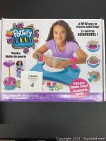 Photo of Pottery Cool Studio pottery wheel kit box showing child molding clay on a blue wheel with pink tools