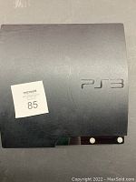 Top view of black Sony PlayStation 3 console showing PS3 logo and surface condition.