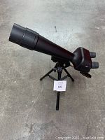 Side view of National Geographic spotting scope mounted on tripod showing full length and dual eyepieces.