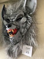 Full front view of the werewolf latex mask with fur, ears, open mouth, and teeth visible.
