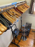 Wide view of all items including shoe rack, clothes racks with wooden hangers, stepping stool and chrome triple holding stand